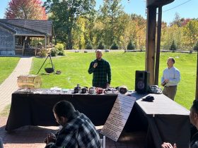 Speaker addressing attendees beside the raffle table at the 2026 WCAMPWA Sporting Clays Fundraising event